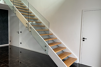 Moderne Treppe mit Holzstufen und Glasgeländer