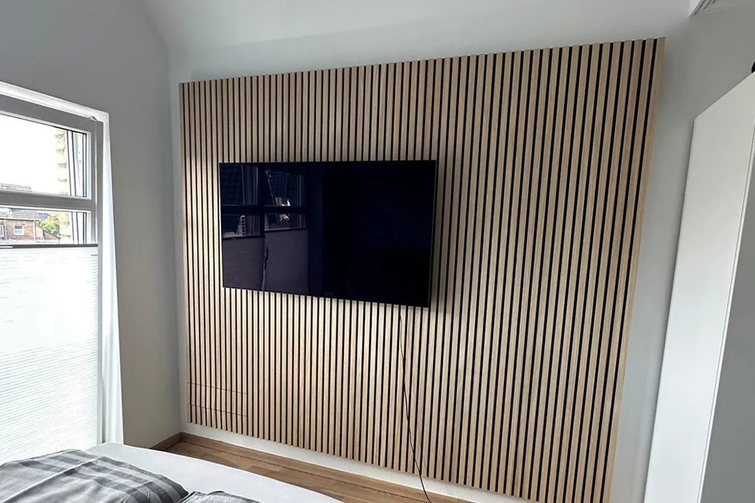 TV-Wand mit vertikalen Akustiklamellen aus Holz